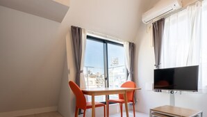 A modern apartment with a dining area, a TV, and a balcony with a city view. - Laffitte Ryogoku (Tokyo)