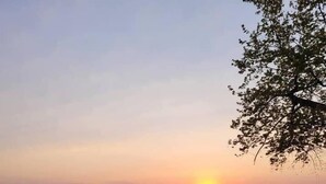 Dos sillas mirando al atardecer sobre un cuerpo de agua.