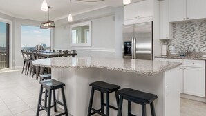 A modern kitchen with a large island, stainless steel appliances, and a view to the outside. - Beautiful 3 bedroom, 3 bath condo is located in the popular luxury building, Gateway Grand (Ocean City)