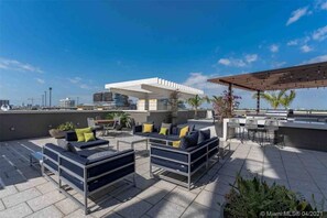 Relax on the rooftop with comfortable seating and a pergola structure.