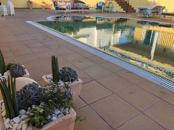 A pool area with tiled flooring, potted plants, and outdoor seating. - Luxury Villa With Private Swimming Pool (Albufeira)