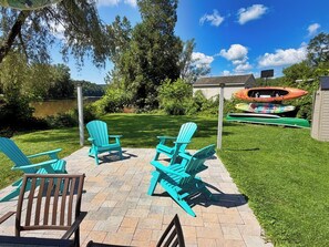 A patio area with outdoor seating, kayaks, and a view of a lake. - Beau Rivage Waterfront, kayak, SUP, great fishing, swimming, fire pit, updated (Portlandville)