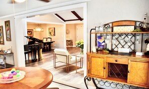 Enjoy a meal in the dining area with a table and chairs, piano, and decorative cabinet.