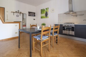 Eine moderne Küche mit Esstisch, Stühlen und Herd.