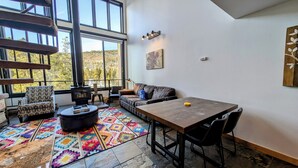 Un salon chaleureux avec une cheminée, un canapé, une table basse et un tapis.
