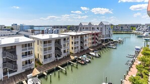 A waterfront hotel with multiple balconies, a dock with boats, and a marina.
