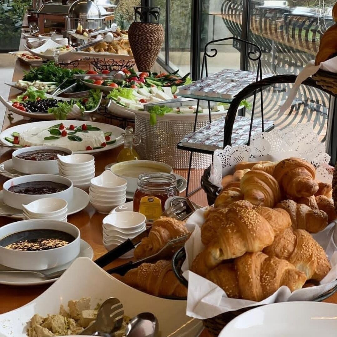 A buffet with various food items including salads, pastries, and condiments.