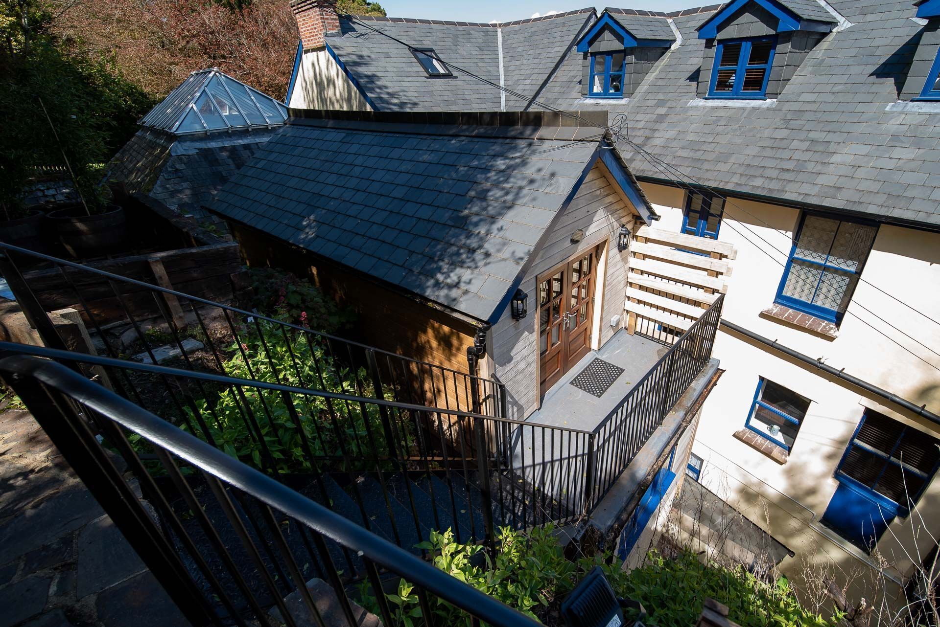Un immeuble à plusieurs étages, doté d’un toit en pente, d’un escalier en bois et d’un balcon.