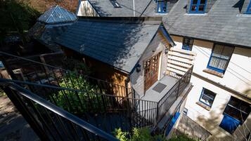 Un immeuble à plusieurs étages, doté d’un toit en pente, d’un escalier en bois et d’un balcon.