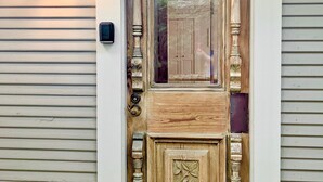 A wooden front door with a decorative arch and a small step leading up to it.