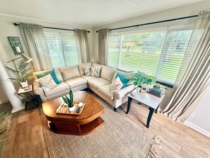 A living room with a sectional sofa, a coffee table, and a side table with a lamp.