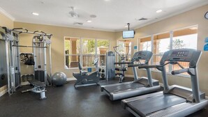 A gym with treadmills, weight machines, and a rowing machine.