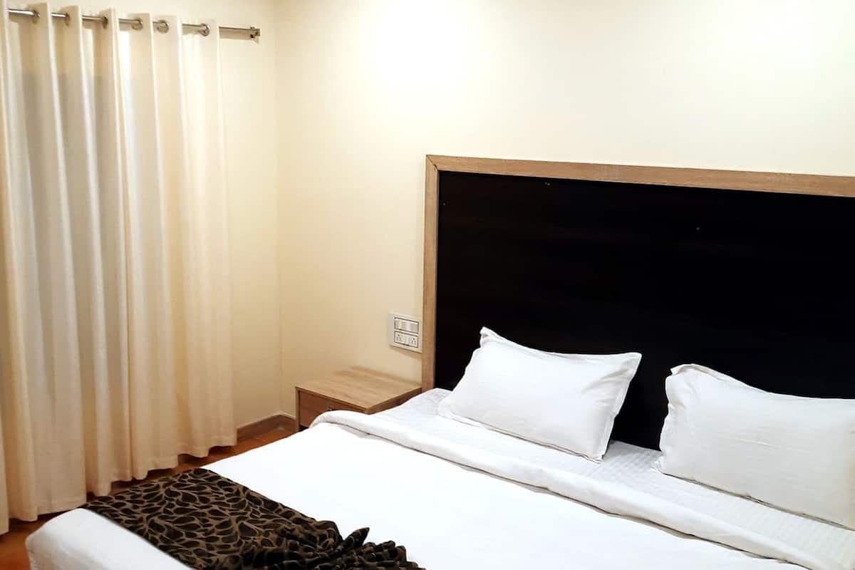 A neatly made bed with white linens, a giraffe-patterned blanket, and a white towel.