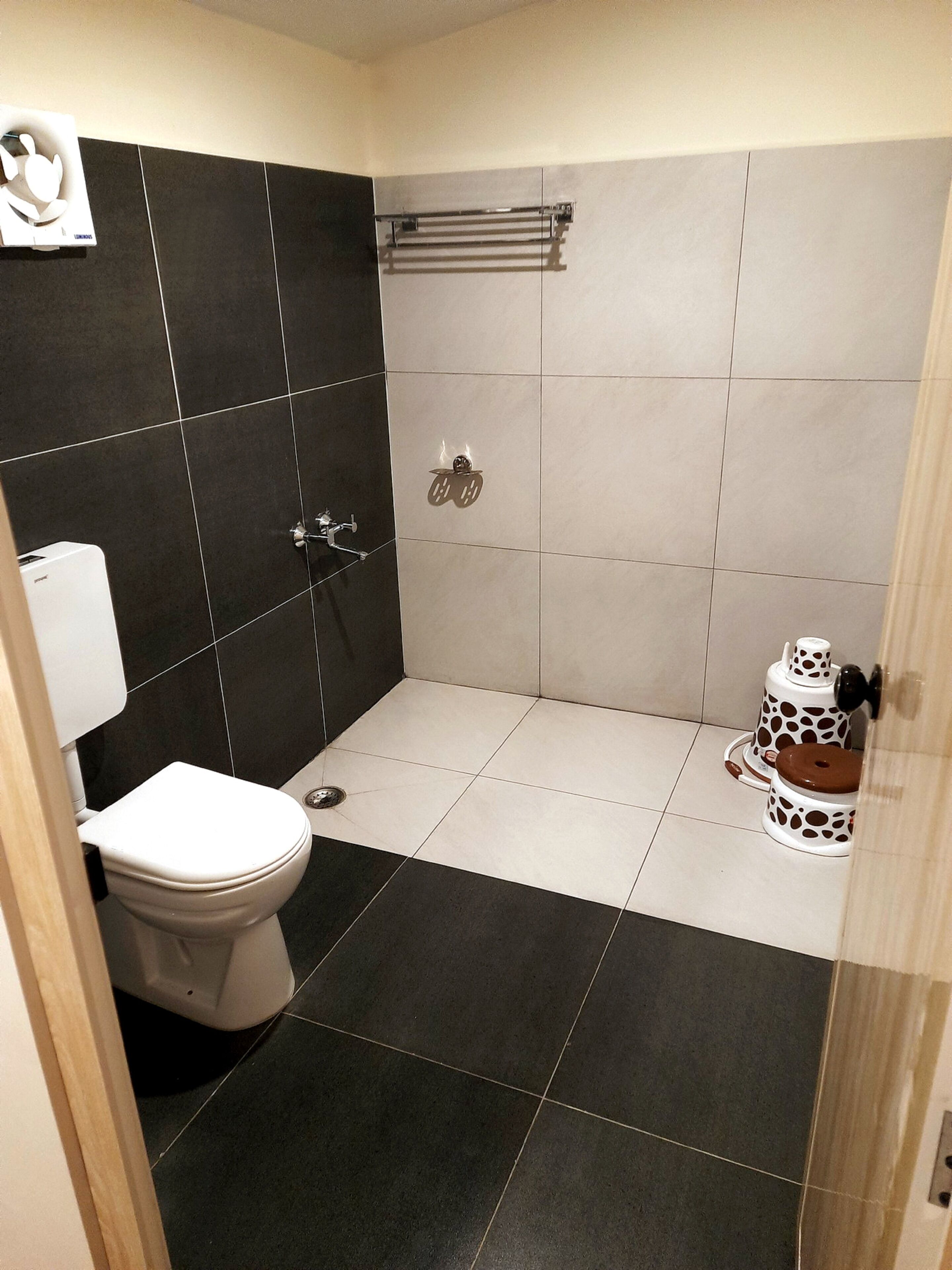 A bathroom with a toilet, a shower, and a sink.