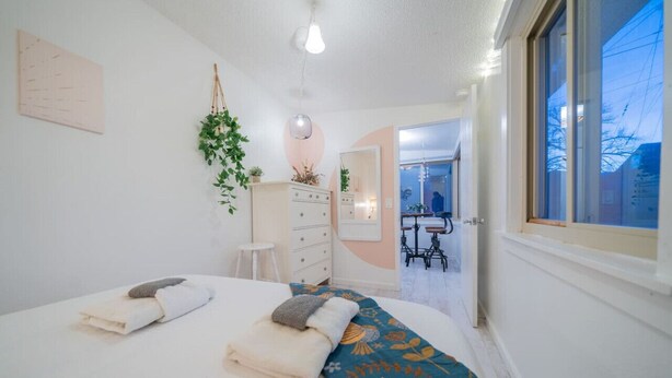 Un dormitorio con cama, cómoda, espejo y ventana.