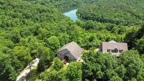 An aerial view of a property with two main buildings surrounded by dense forest and a river. - Welcome to “Hillside Haven” – The Perfect Family and Friends Vacation Spot (Burnside)