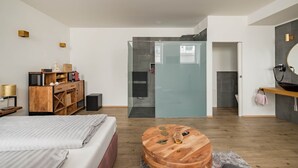 A modern bedroom with a bed, wooden dresser, and a round wooden coffee table. - Prime Loft, Prime Loft near Naschmarkt (Vienna)