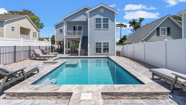 A two-story house with a swimming pool, a balcony, and a covered staircase.