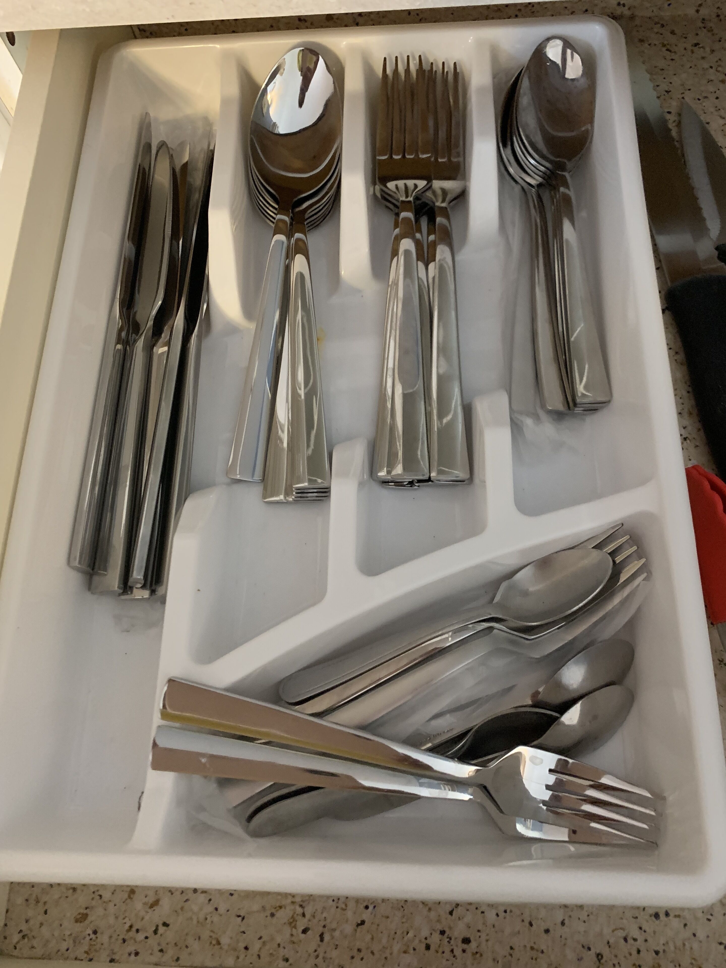 En skuffe med forskelligt sølvbestik, blandt andet gafler, skeer og knive.