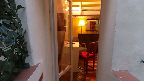 A narrow hallway leading to a dining area with a table and chairs.