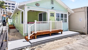 A small, single-story building with a porch and a bench. - Island Vibes House Steps from Clearwater Beach (Clearwater Beach)