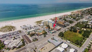 An aerial view of a coastal town with a beach, parking lots, and buildings. - Island Vibes Cottage Near Clearwater Beach (Clearwater Beach)
