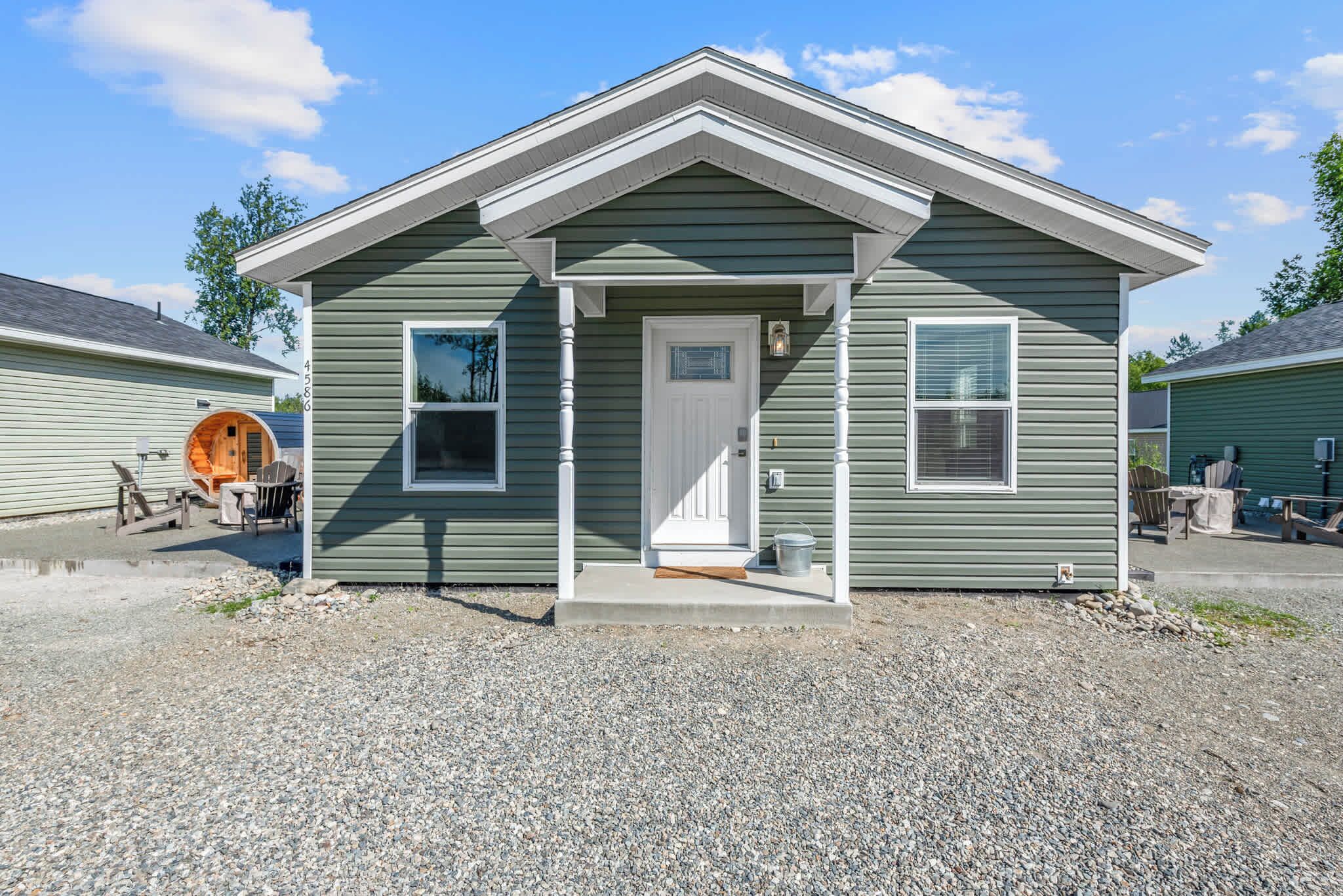 A small, single-story building with a front porch, a door, and two windows.