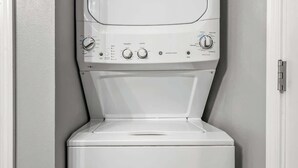 A compact, white, wall-mounted washer and dryer unit with control knobs and a start button.