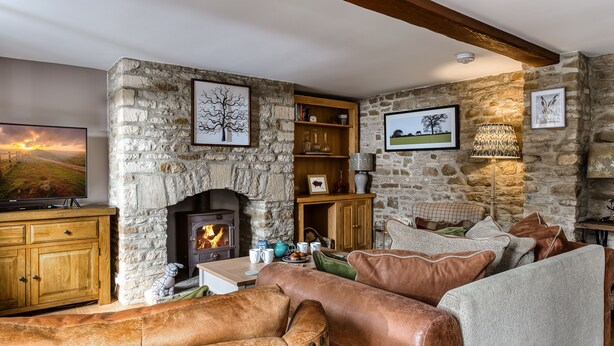 A stone fireplace, a television, a sofa, and a bookshelf in a cozy living room. - Old Stable Cottage, Kingham, Chipping Norton (Kingham)