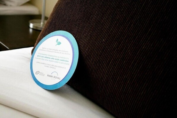 A pillow with a circular tag that includes text and a logo, likely indicating hotel branding or amenities. - 2 BR Suite within Walking Distance to Palacio San Martin (Buenos Aires)