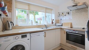 Una cocina moderna con lavavajillas, horno y fregadero integrados.