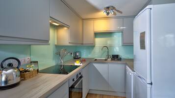 Mikrobølgeovn, ovn, oppvaskmaskin og høy barnestol