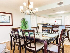 A dining area with a large round table, chairs, and a chandelier.