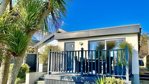 A modern two-story house with a balcony, surrounded by palm trees and other greenery. - 16 Beatrice Avenue, Shanklin, isle of Wight (Shanklin)