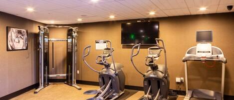 A fitness center with treadmills, elliptical machines, and a weight machine.