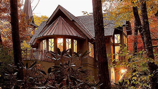 A wooden cabin with a gabled roof, surrounded by trees and foliage. - Club Lodges at Trillium - 3 Bedroom Presidential (Cashiers)