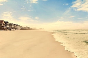 A beach with a row of houses along the shore.