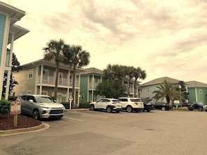 A parking lot with several cars, a 'TOW AWAY' sign, and multi-story buildings with balconies.