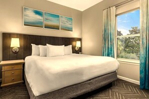 A hotel room with a large bed, two bedside tables with lamps, a headboard, and a window with curtains. - Destin | Romantic Beach Retreat | Pool + Beach (Destin)