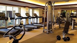A gym with treadmills, a weight bench, and exercise equipment.