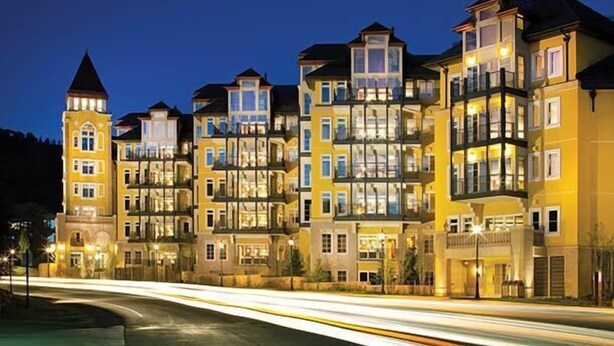 A multi-story hotel with balconies, large windows, and a tower-like structure.