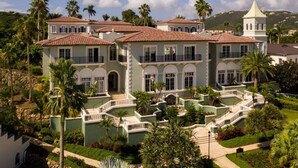 A large, multi-story building with a symmetrical facade, multiple balconies, and a central courtyard with palm trees. - Ritz Carlton Club, St Thomas - 3 Bedroom (St. Thomas)