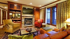 Cozy living room with a fireplace, television, and comfortable seating for relaxation.