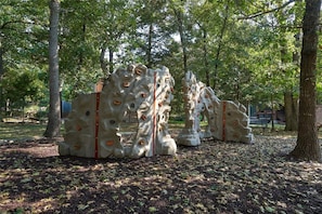 Une installation de sculptures dans un parc, avec des arbres et des bancs en arrière-plan.