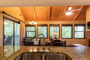 A kitchen with granite countertops, a double sink, and a ceiling fan.
