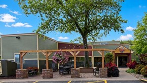 A building with a covered patio area, outdoor seating, and a sign that reads 'Malligans.'