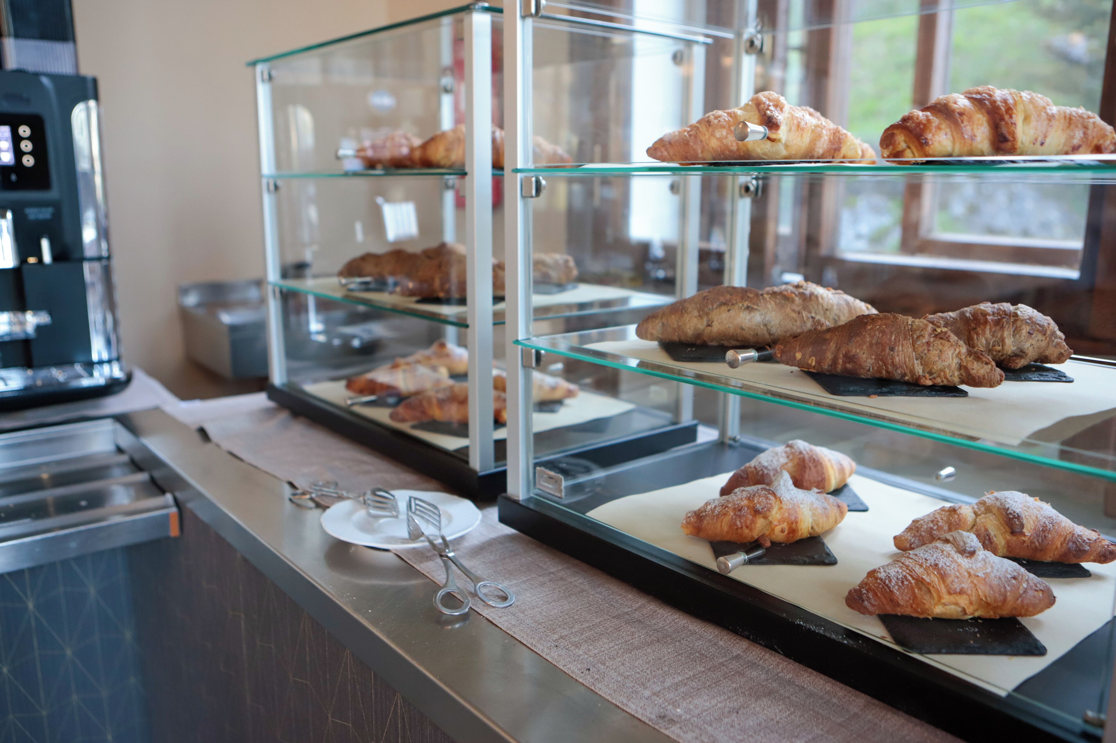 Una vitrina de pastelería con cruasanes y otros dulces.
