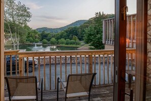Enjoy a serene riverside view from this deck with two comfortable chairs.