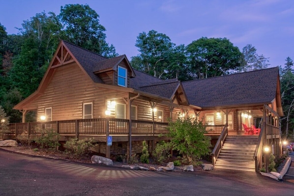 Surrounded by lush vegetation, this lodge features a charming front porch and a staircase leading to the entrance.