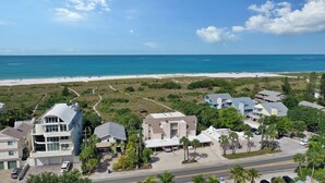 Zona residencial costera con casas, una calle y una playa al fondo.